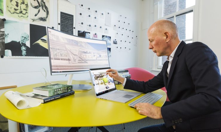 Ben achter een bureau met Surface Book