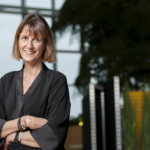 Valérie Pierre, COO Microsoft Belux poseert al lachend in de ontmoetingsruimte van het nieuwe kantoor van Microsoft België.