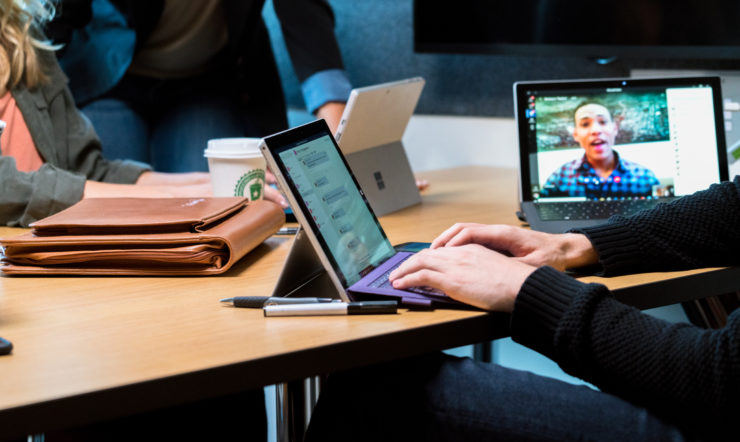 A group opf people around a desktop having a Teams meeting