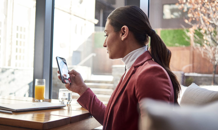 una persona con un telefono davanti a una finestra