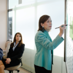CFO going over numbers in a meeting using the Surface Hub. Business attire