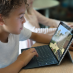 Children, students in classroom playing Minecraft on Surface Go. Contextual education.