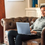 a man sitting in a living room with a leather chair