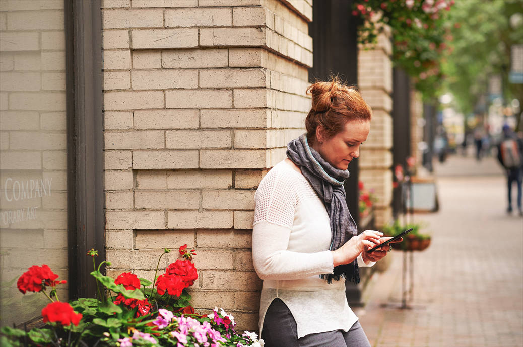 a woman sitting on a sidewalk