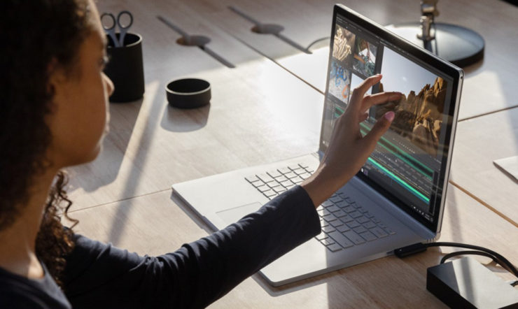una persona che utilizza un computer portatile seduta sopra a un tavolo