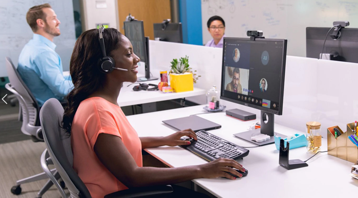 een vrouw die bij een bureau zit en een laptopcomputer gebruikt