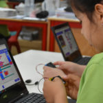 um rapaz jovem a utilizar um computador portátil