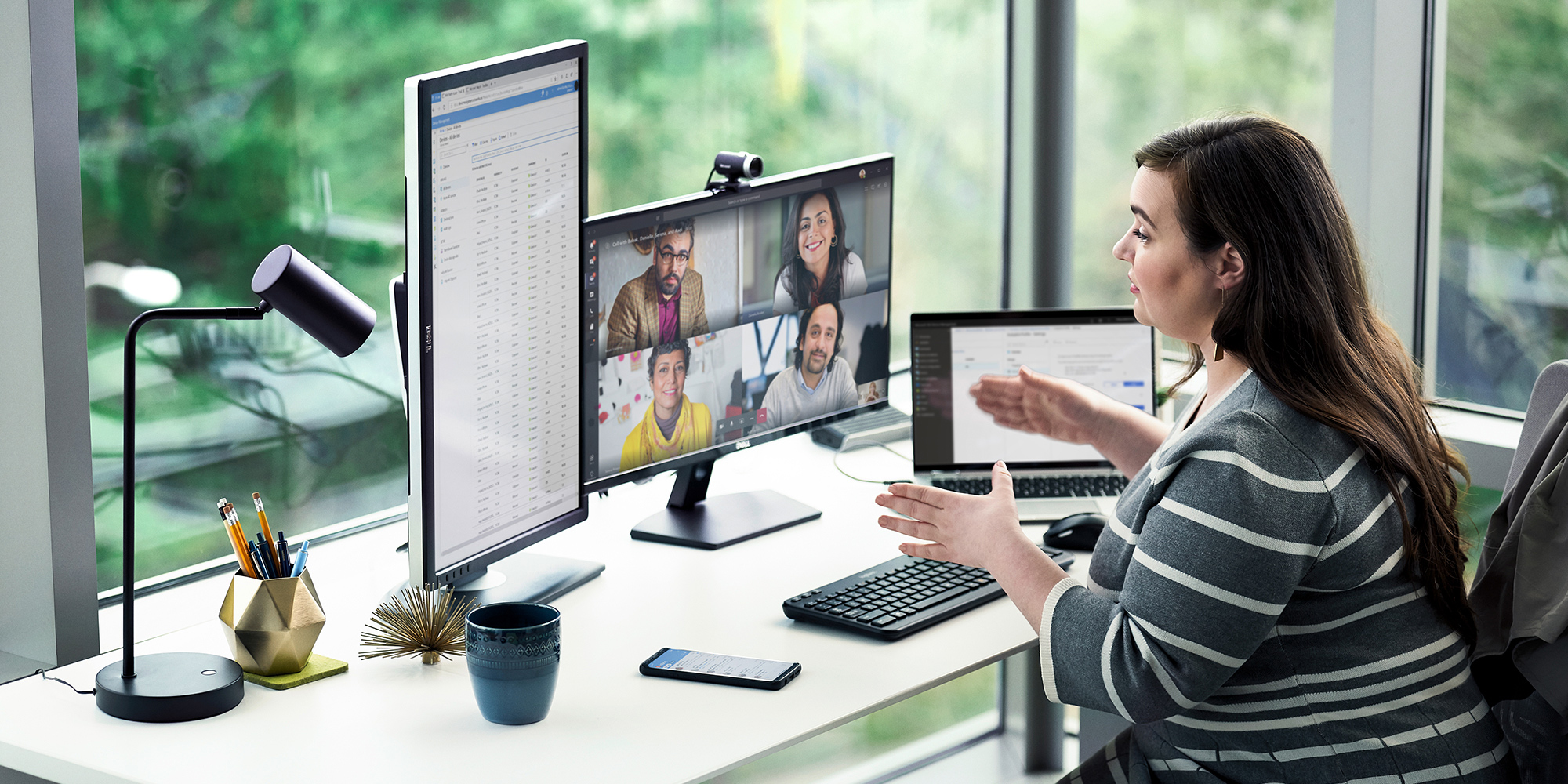 a person sitting at a desk in front of a laptop computer in a virtual meeting