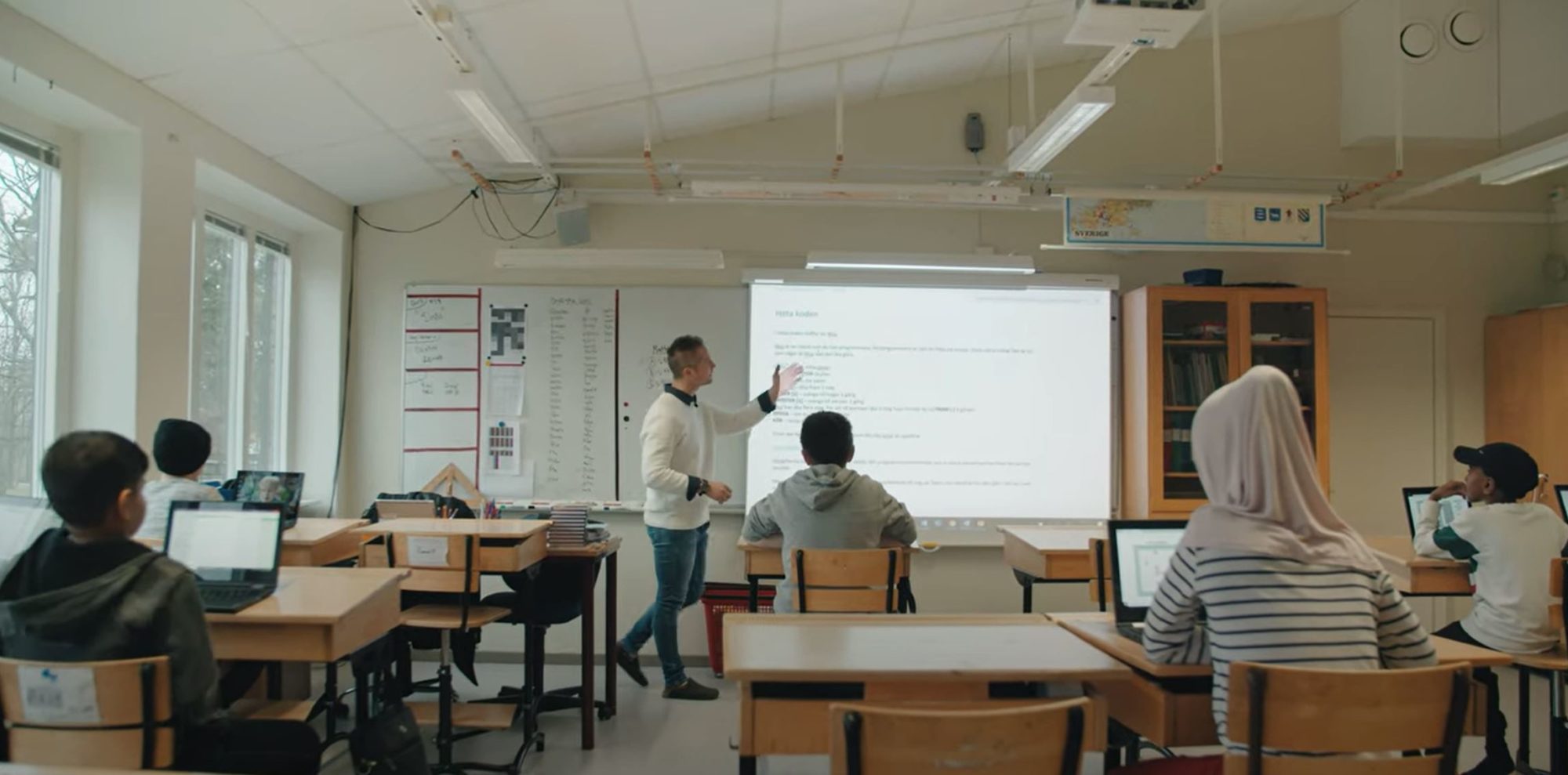 en grupp människor som sitter vid ett bord i ett rum