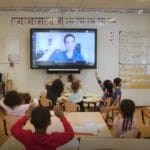 een groep mensen die aan een lijst zitten