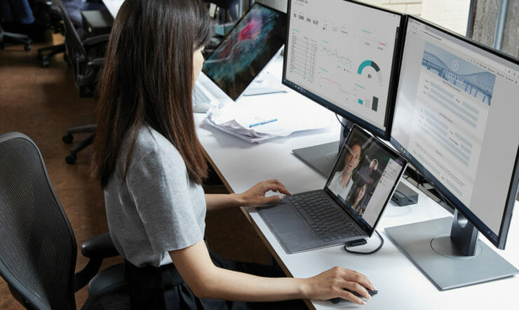uma pessoa sentada em uma mesa na frente de um computador portátil