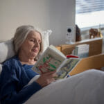 Margaret Whitlam sitter på en seng