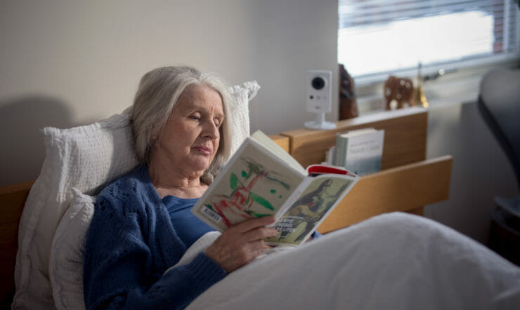 Margaret Whitlam sitter på en seng