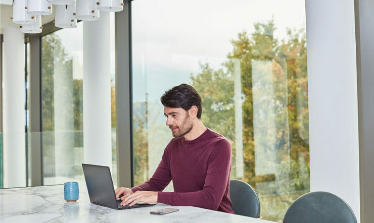 a person sitting at a table using a laptop