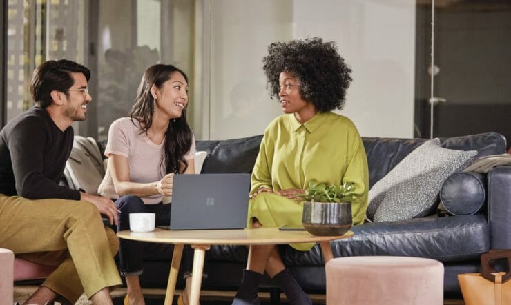 Employees collaborate in front of Surface devices