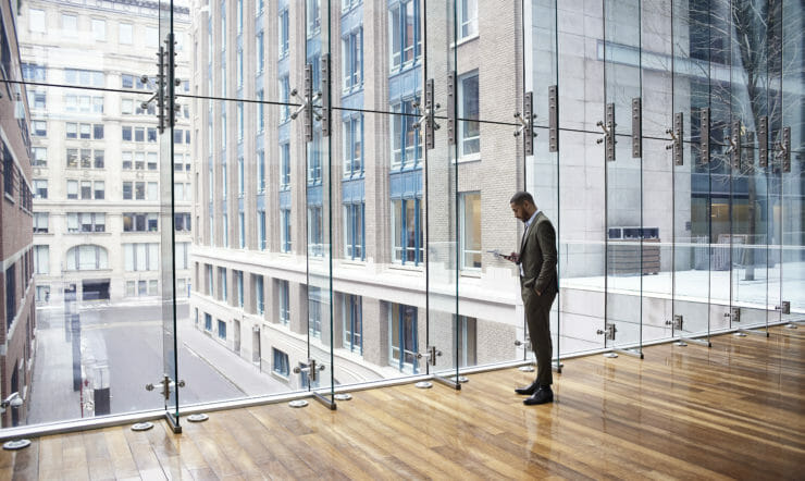 man in front of glass building