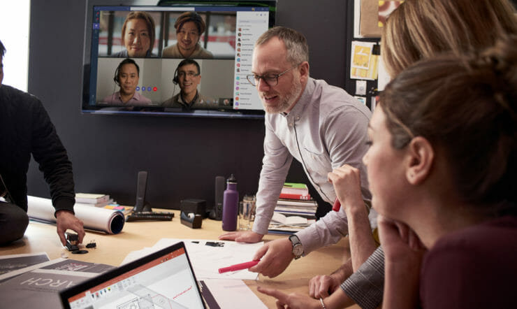 Female & Male employees collaborating using PowerPoint and Microsoft Teams.