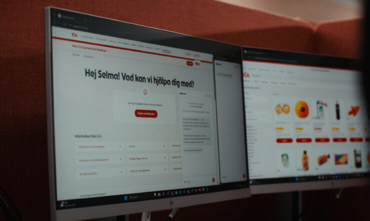 Två datorskärmar visar webbplatser från ICA. På den vänstra skärmen syns en kundservicesida med texten ”Hej Selma! Vad kan vi hjälpa dig med?”, medan den högra skärmen visar en sida med bilder på olika produkter och kategorier.